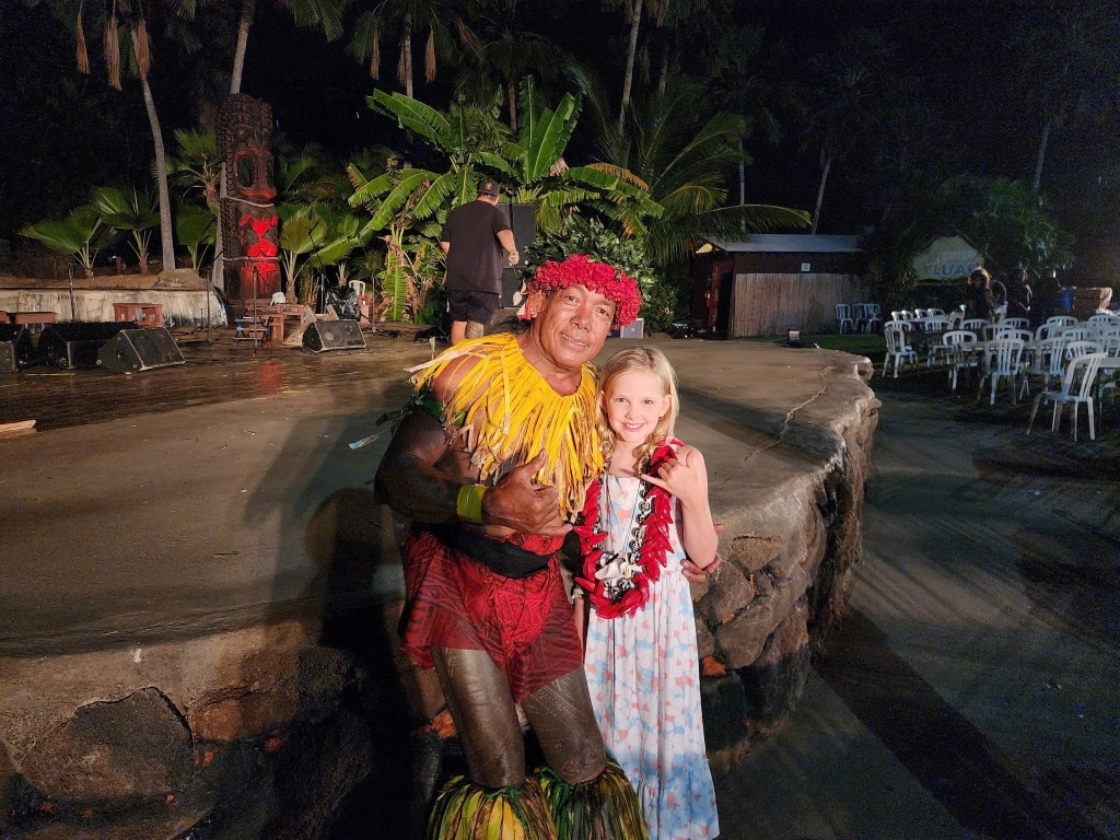 Wish Kid Ruby posing with chief at Hawaiian luau