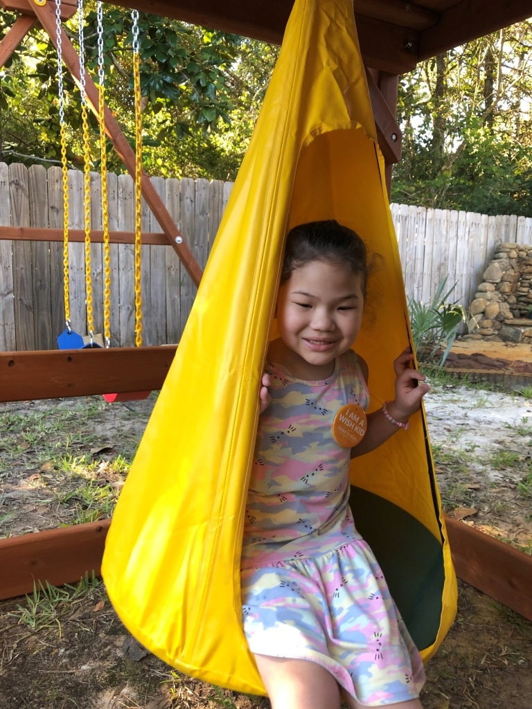 Wish Kid Evelyn swinging on her new playset